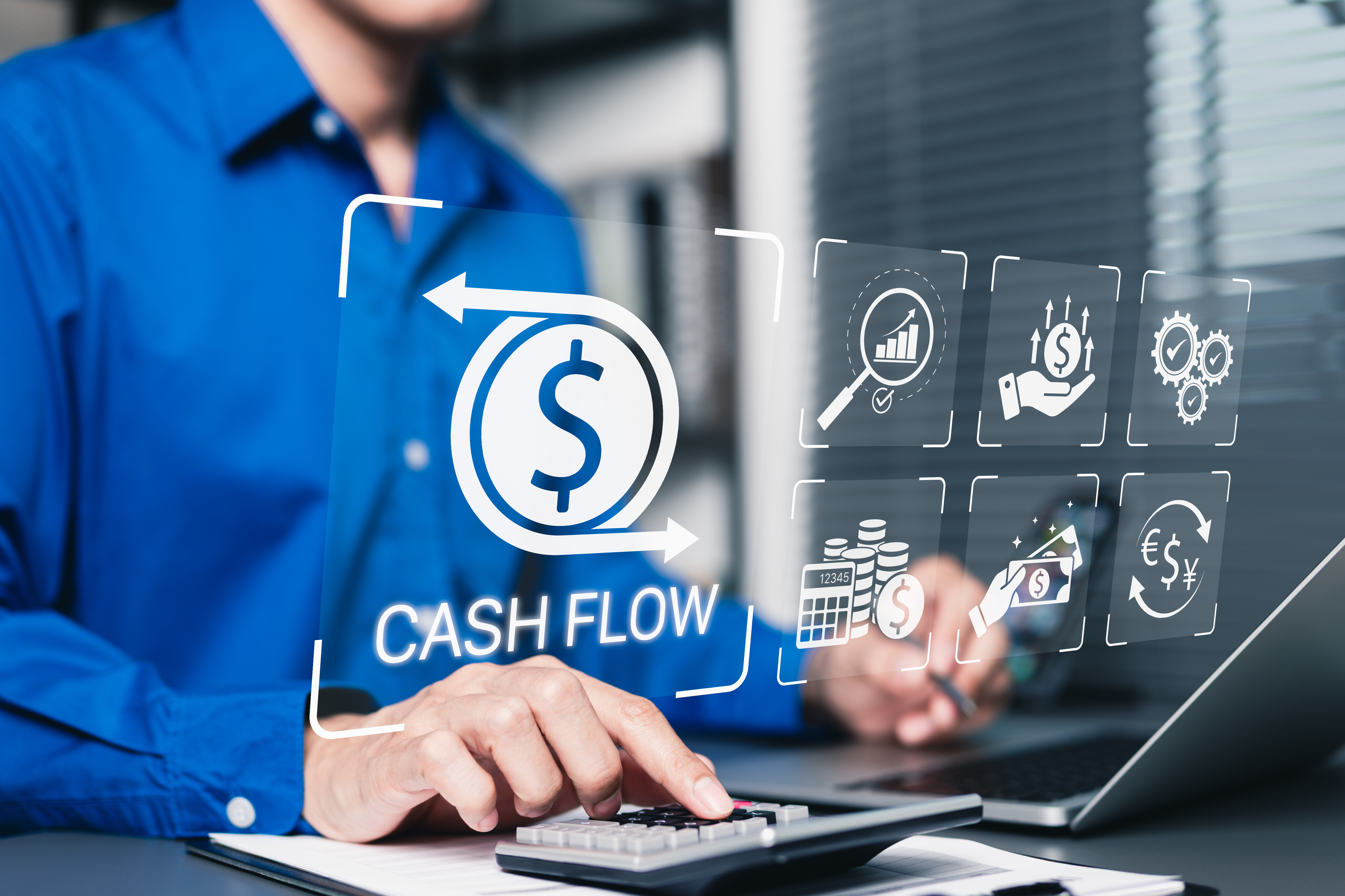Person using a calculator, while a cash flow symbol is hover above his hand